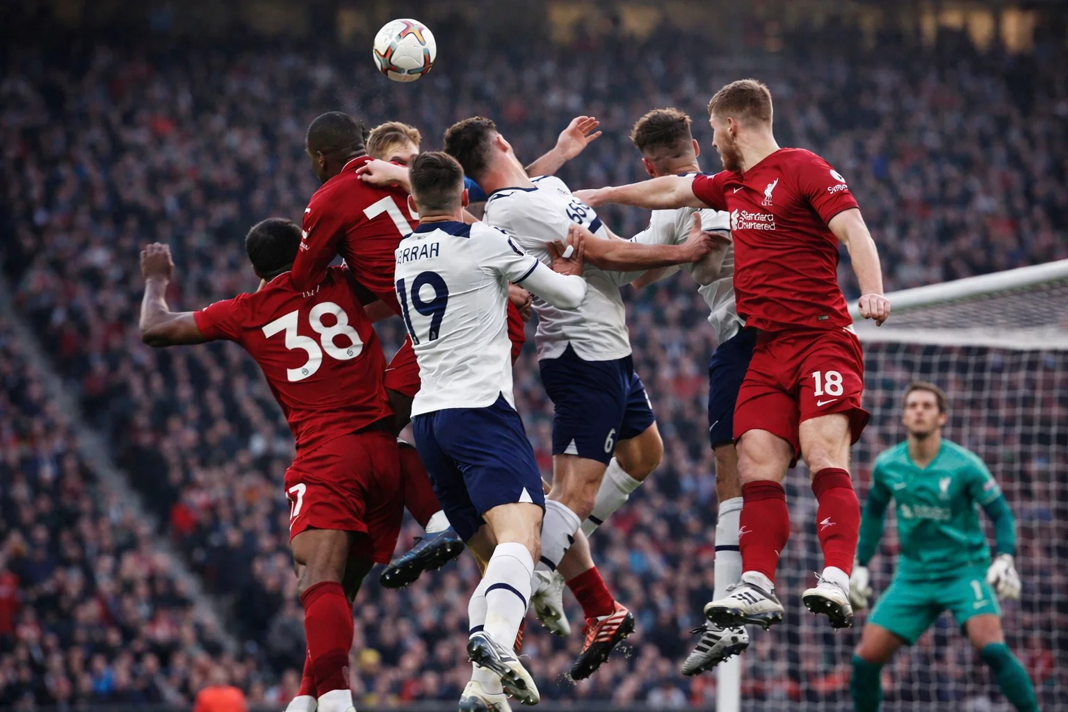 Players competing for a header during a corner kick in a football match