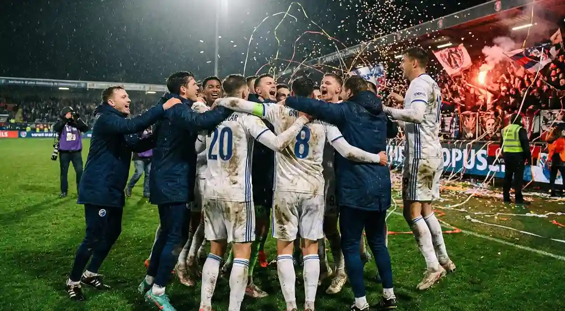 Football team celebrating progression to next round after winning a cup match