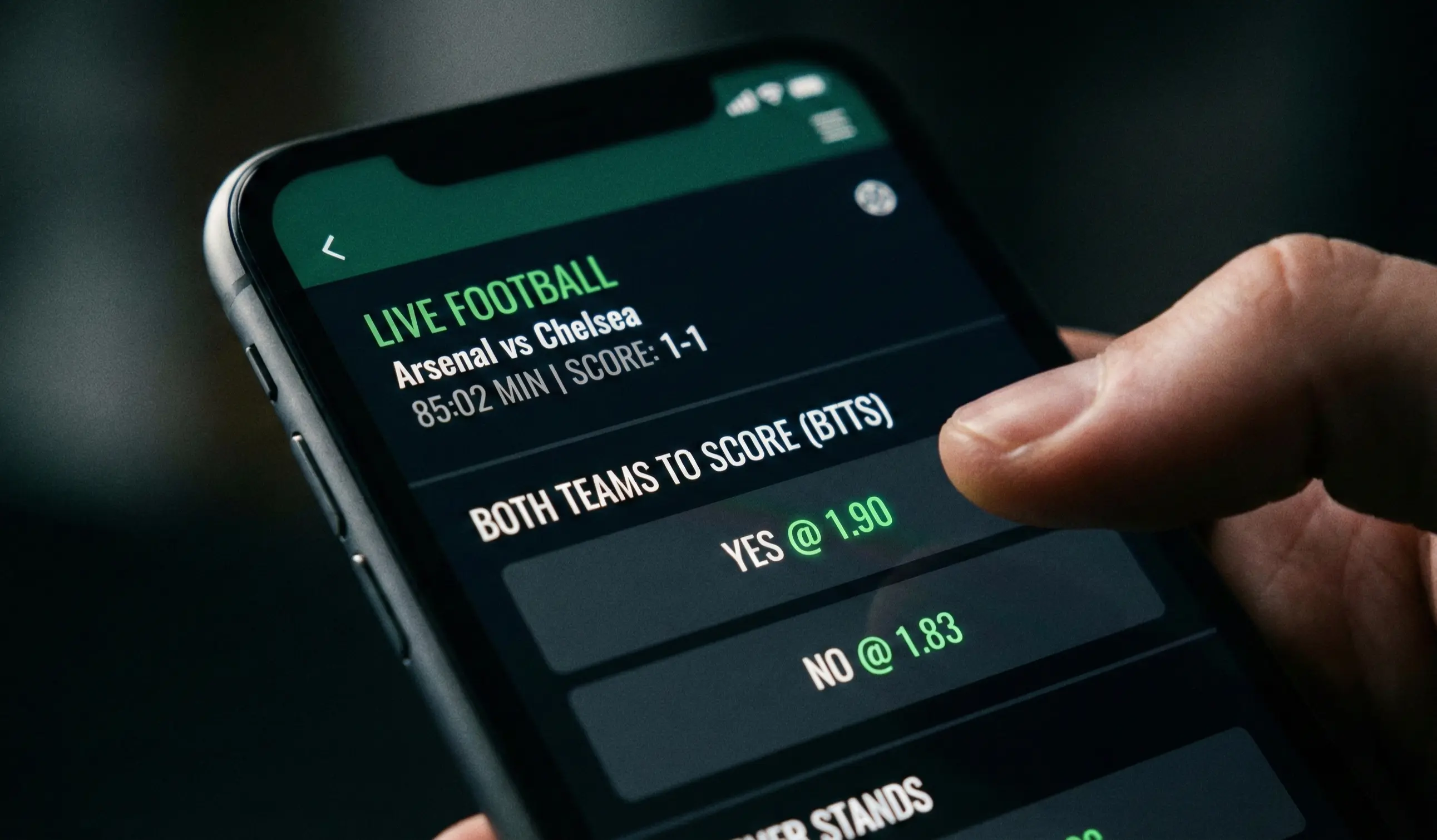 Mobile phone showing live football betting markets with BTTS options